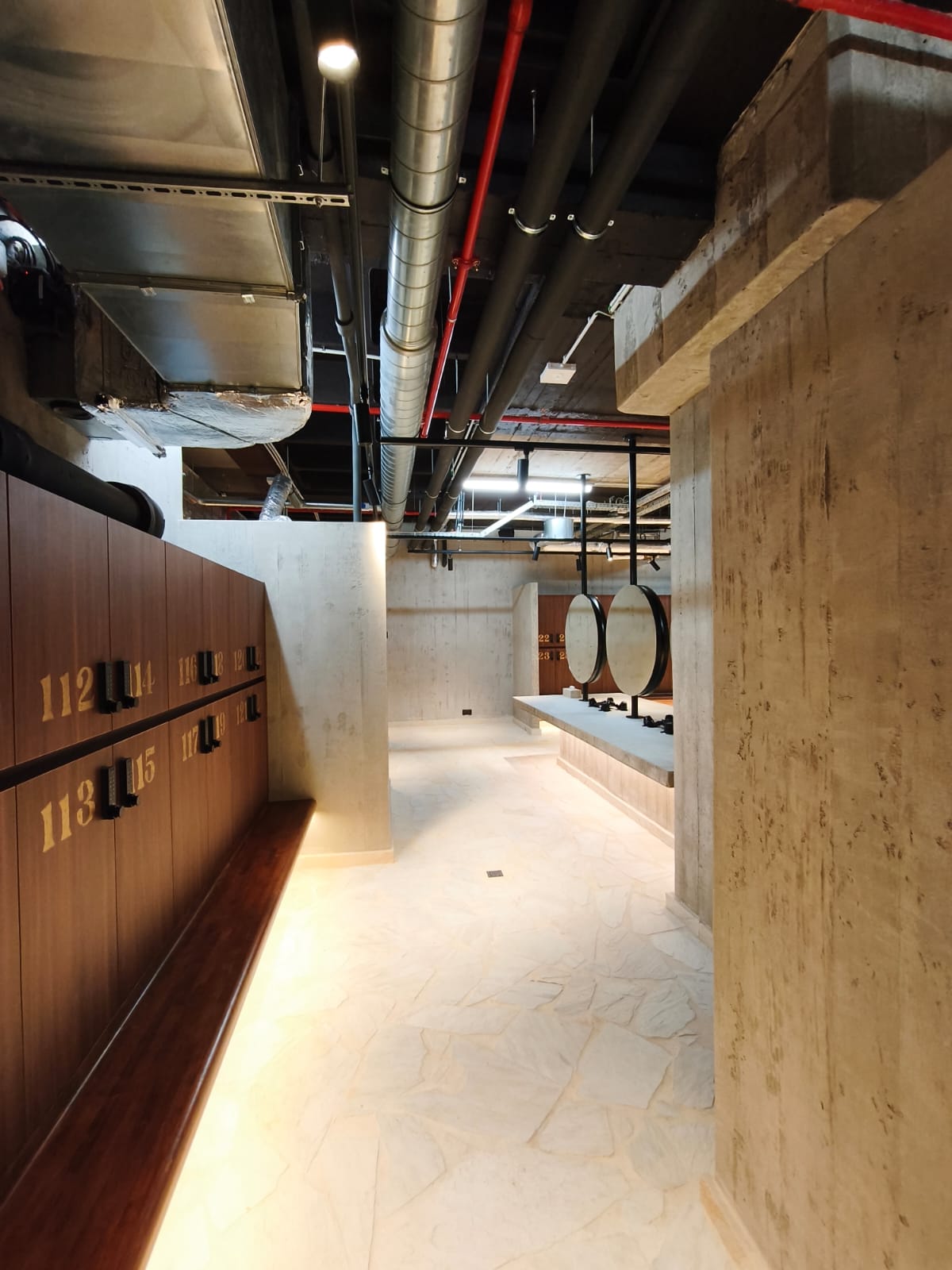 Casiers en bois, plafond technique apparent, murs en béton brut